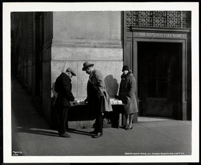 Blinde krantenverkoper, Aaron Weintraub, bij zijn stand op de zuidoostelijke hoek van 7th Avenue en 32nd Street, New York, 1930 door Byron Company